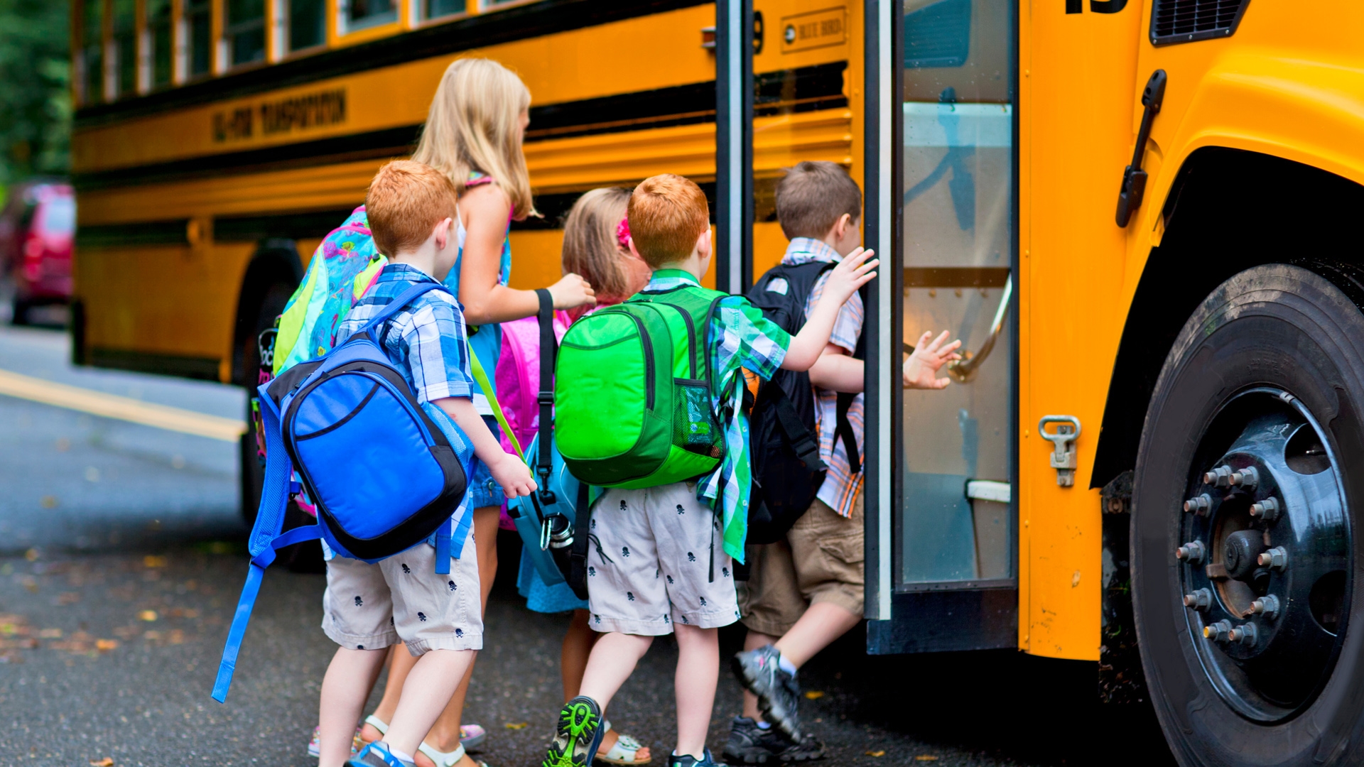Children boarding a school bus in a neighborhood